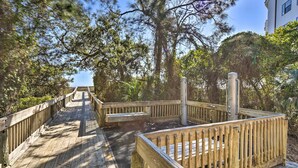 A wooden boardwalk leading to a beach area with benches and a lifeguard stand. - Access to Folly Field Beach & Pools: Coastal Condo (Hilton Head Island)