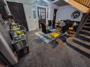 A modern interior with a dining area, staircase, and a view of the outside.
