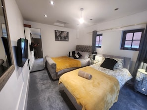 Een hotelkamer met twee bedden, een grote spiegel, een wereldkaart aan de muur en een raam met gordijnen.