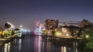 A nighttime cityscape with a river, illuminated buildings, and a bridge. - Annexe Ground Apartment Charming Tudor style Apartment (Stretford)