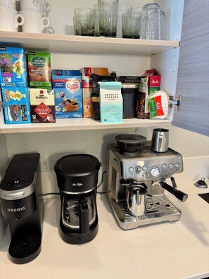 Un espace dédié au café, avec un assortiment de capsules de café et deux machines à café.