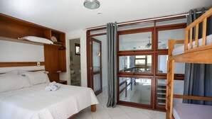 Une chambre d’hôtel avec un lit, des meubles en bois, un balcon avec vue et une porte-fenêtre coulissante.