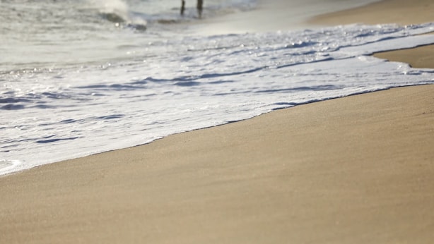 Une plage de sable où les vagues se brisent près du rivage.