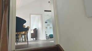 A staircase leading to a dining area with a piano and chairs.