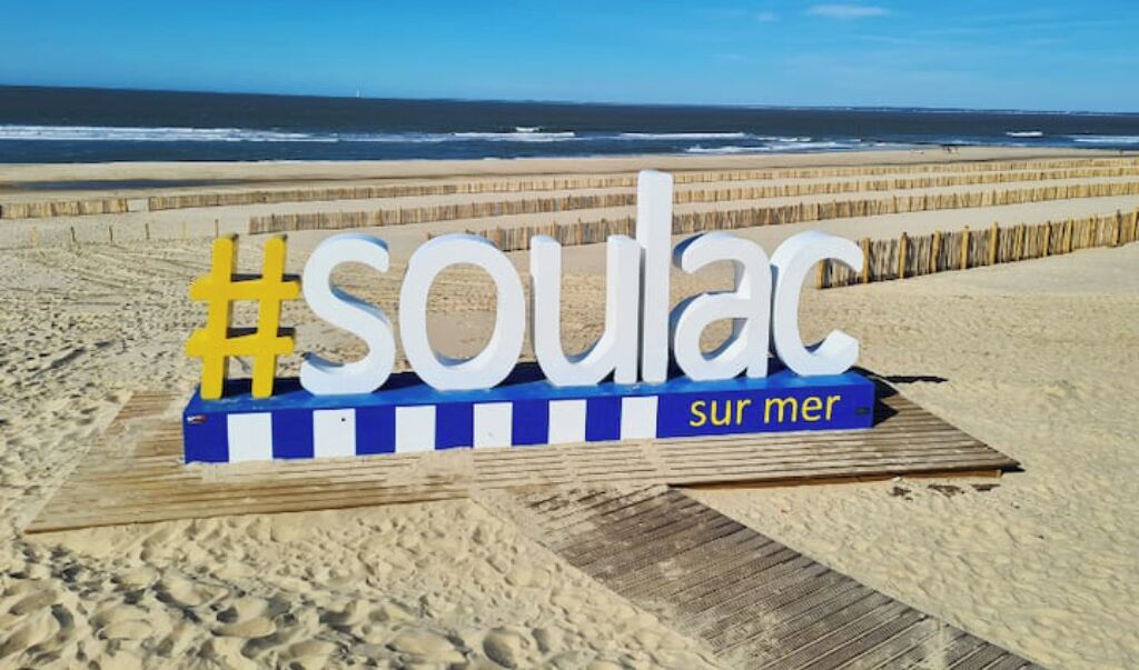 Rannalla oleva kyltti, jossa lukee sanat »Soulac» ja »sur mer».