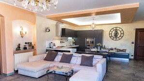 Una sala de estar moderna con un sofá modular, una mesa de centro y una cocina al fondo.