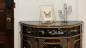 A wall with three decorative mirrors and a framed butterfly artwork on a wooden cabinet. - Ramblei near Rittenhouse Sq / 2 bedroom – Unit B (Philadelphia)