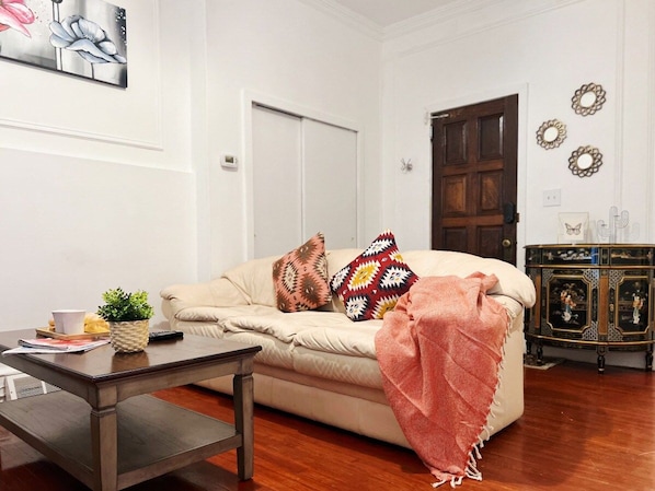 A living room with a sofa, coffee table, and decorative pillows.