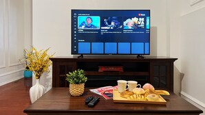 A flat-screen TV mounted on a dark wooden entertainment center, displaying a music streaming service interface with artist suggestions. - Ramblei near Rittenhouse Sq / 2 bedroom – Unit B (Philadelphia)