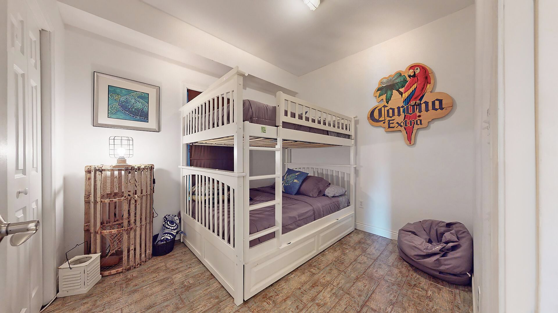 Quarto com cama de solteiro, radiador, quadro emoldurado, placa e um puff.