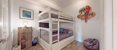 Quarto com cama de solteiro, radiador, quadro emoldurado, placa e um puff.