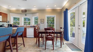 A kitchen with a dining area, a dishwasher, and a 'WELCOME' sign. - Big Pine Turtle House (Big Pine Key)