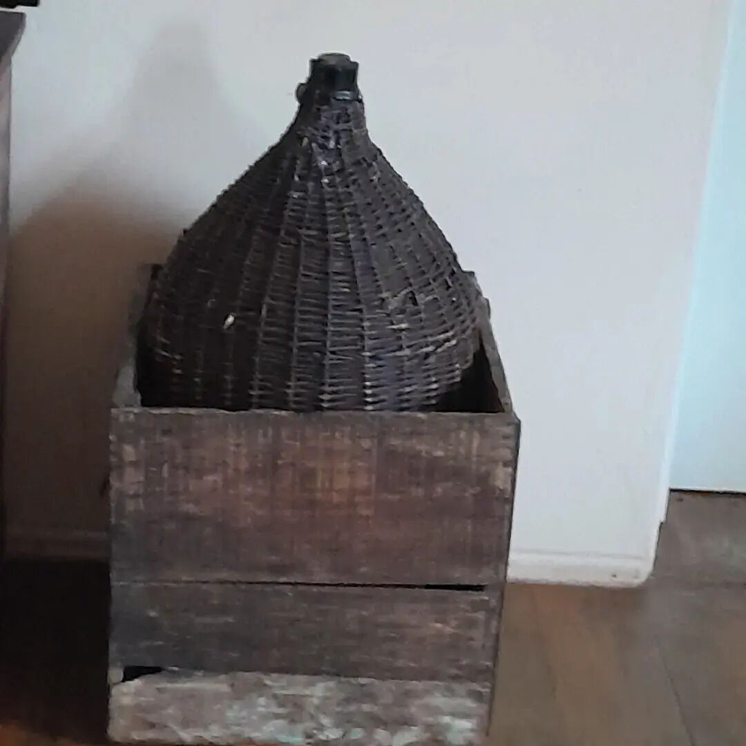 Een rieten mand in een houten kist.