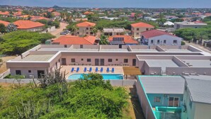 Zona residencial con piscina rodeada de edificios con tejados rojos y vistas despejadas del barrio.