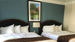 A hotel room with two beds, a framed picture on the wall, and a wooden floor. - Rex Motel (Ventura)