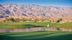 A golf course with a flagstick, water hazards, and a mountainous backdrop. - Relaxing 1BR at Club Wyndham Indio – Desert & Golf Getaway (Indio)
