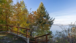 A wooden staircase leading to a dock by a lake, surrounded by autumn foliage.