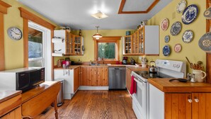 A compact kitchen with wooden cabinets, a microwave, a dishwasher, and a stove.