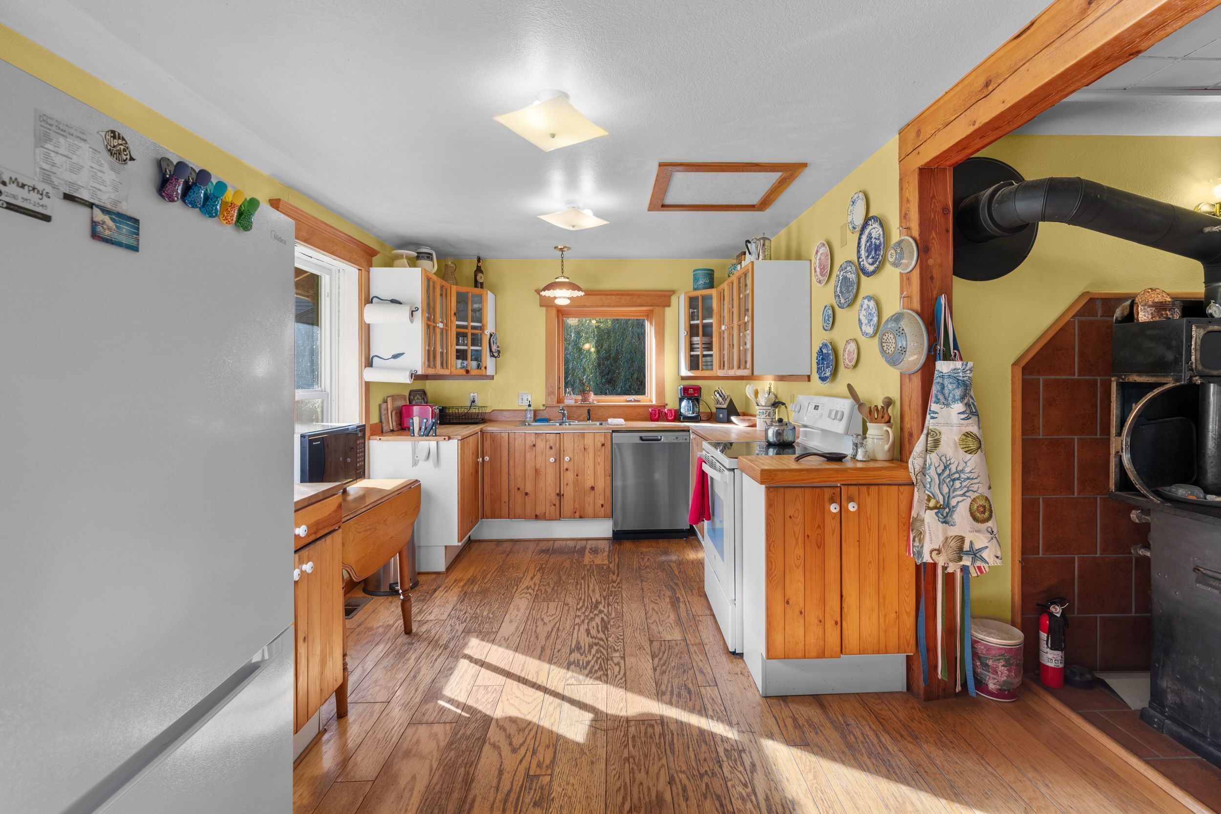 A kitchen with wooden cabinets, a built-in oven, and a large window.