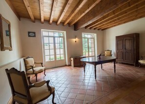 Una habitación amplia con un alto techo de madera, ventanas grandes y una mesa central.