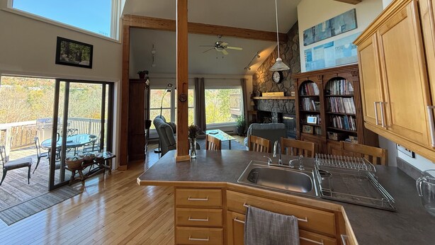 A spacious kitchen with a large island, wooden cabinets, and a stone fireplace. - Marvelous 3-bedroom townhome in Hunter Mountain next to the slopes (Lanesville)