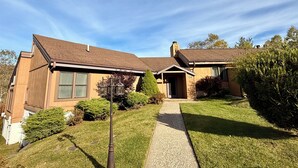 A two-story house with a front porch, a visible chimney, and a well-maintained lawn. - Marvelous 3-bedroom townhome in Hunter Mountain next to the slopes (Lanesville)