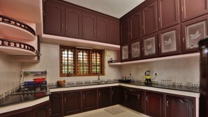 Una cocina con armarios de madera oscura, una estufa a gas y una ventana con vista a la vegetación.