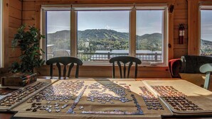 A wooden cabin with a large window overlooking a mountainous landscape.
