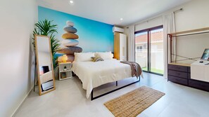 A bedroom with a bed, bedside table, lamp, and a wall art piece.