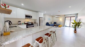 A modern kitchen with white cabinets, a granite countertop, and a central island with bar stools.