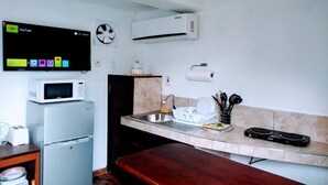 Angolo cottura funzionale con forno a microonde, frigorifero e televisore a schermo piatto che mostra YouTube.