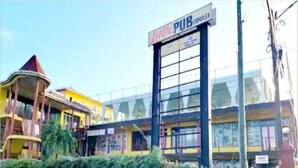 Un edificio con un cartello che recita "PUB COMPLEX" e un'ampia vetrata.