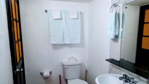 Un bagno piccolo con il water, un lavandino e uno specchio.