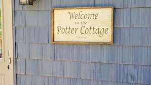 A welcome sign for the Potter Cottage with a vintage design and a date of establishment.