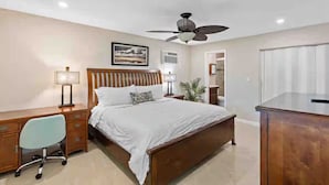 A bedroom with a bed, desk, chair, and ceiling fan. - 2BR - Hot Tub W/ Peaceful Backyard • 1 Mi to Beach (Boca Raton)