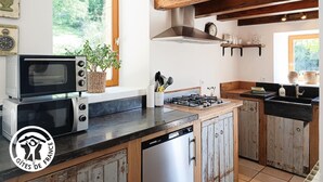 Uma cozinha com fogão, micro-ondas e armários de madeira.