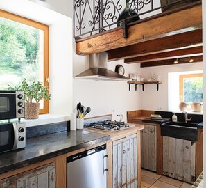 A kitchen with a stove, microwave, and wooden cabinets.
