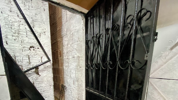 A room with a staircase leading to a lower level, a metal gate with decorative bars, and a tiled floor. - Apartment in Coroado, Manaus, close to buses, restaurants and markets. (Manaus)