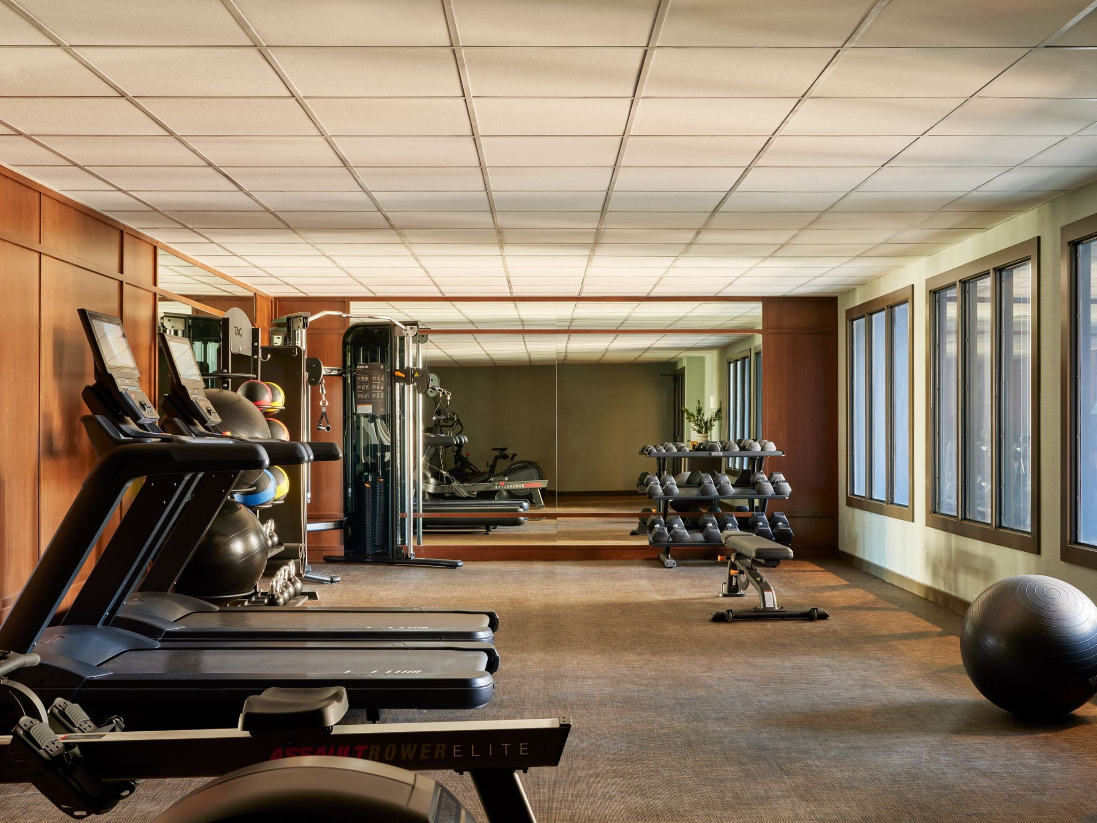 A gym with treadmills, exercise balls, and weight machines.