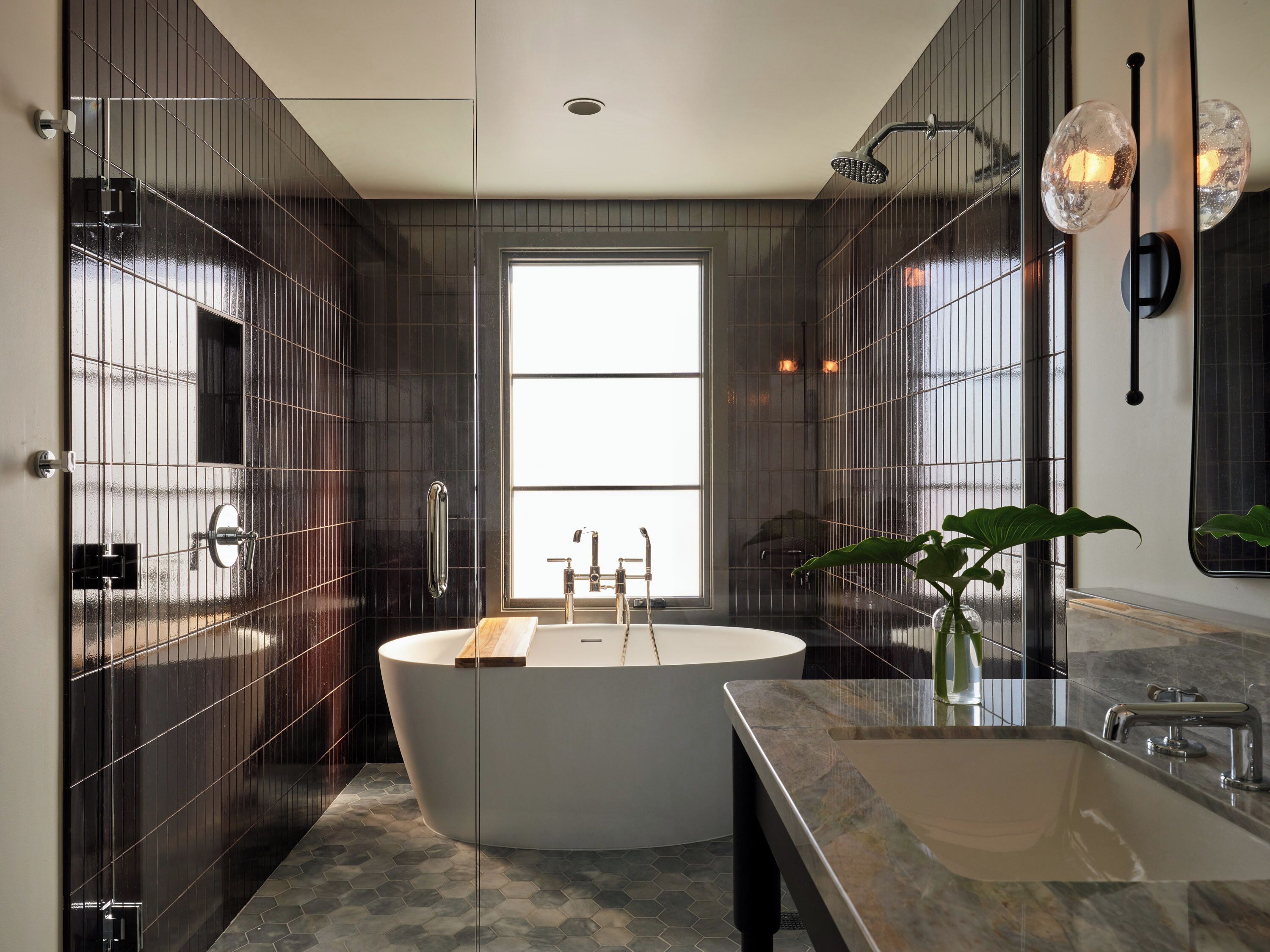 A modern bathroom with a freestanding bathtub, a large mirror, and a sink.