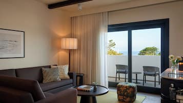 Una sala de estar moderna con un sofá, una mesa de centro y vistas al exterior a través de un amplio ventanal corredero.
