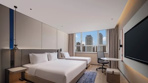 A modern hotel room with a large bed, two bedside tables, a desk, and a large window offering a city view. - Holiday Inn Express Qingdao Downtown by IHG (Qingdao)