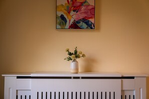 Un radiateur blanc sur lequel est posé un vase de fleurs.