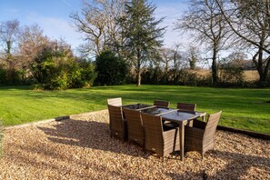 Un espace extérieur aménagé avec une table et des chaises, le tout entouré de gravier.