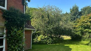 Il s’agit d’une propriété résidentielle dotée d’une pelouse bien entretenue, d’une maison en briques et d’une variété d’arbres et d’arbustes.