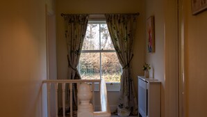 A room with a window, a radiator, and a white railing. - Red House - Private Bathroom (Hinton)