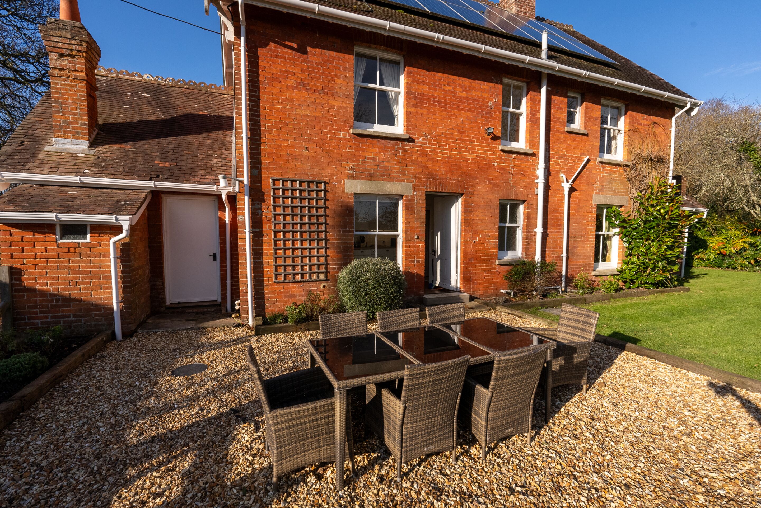 A brick house with a patio, a table, and chairs.