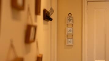 A hallway with a door on the right and framed pictures on the wall.