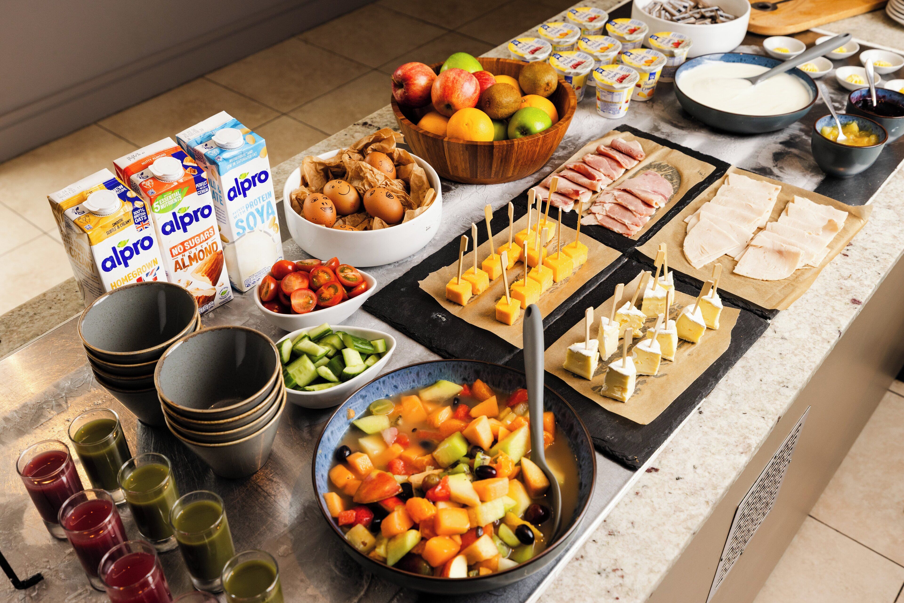 Una taula de buffet amb diferents aliments, com fruita, formatges i carn.