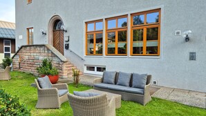 A modern building with large windows, a stone staircase, and outdoor wicker furniture. - Schmitten 27 - Room 4 200m From ski Lift (Zell am See)